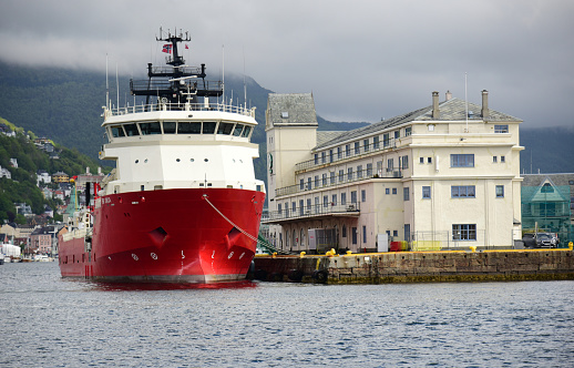 Cargo and passenger ferry in the harbor. Shipyard on the background.