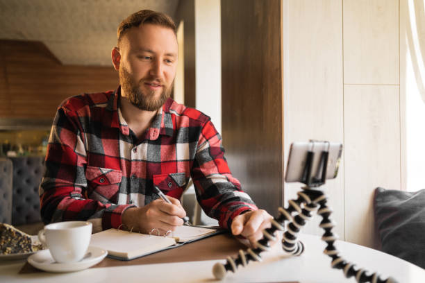 istock online webinar student in cafe using smart phone and wireless internet, blogger writing video blog for colleagues, technology and business 1402076331
