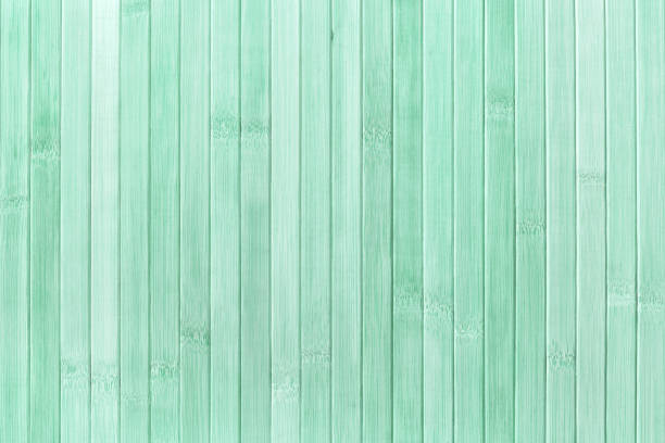 Texture and structure of wooden light green background, macro. Backdrop from grunge painted wood material with pastel cyan color, closeup.