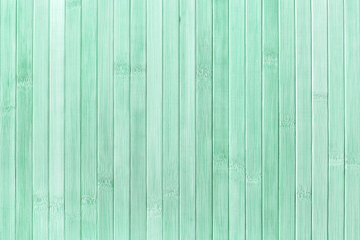 Texture and structure of wooden light green background, macro. Backdrop from grunge painted wood material with pastel cyan color, closeup.