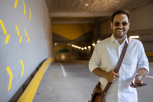 Business man exiting garage and smiling