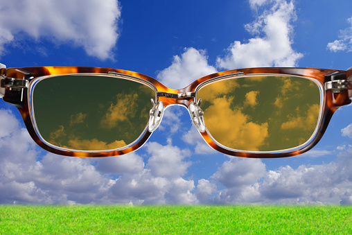 Close-up of cloudscape seen through sunglasses with meadow.