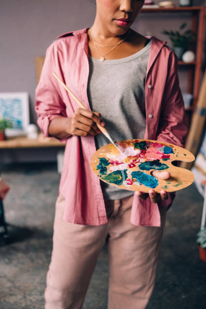 istock An Unrecognizable Mixed-race Professional Artist Painting In Her Studio Using A Wooden Artist's Palette And A Paintbrush 1402082018