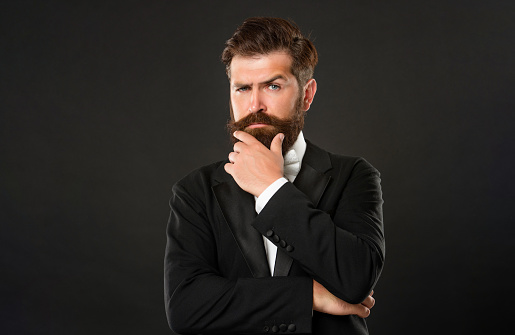 bearded businessman in tuxedo on black background, fashionist.