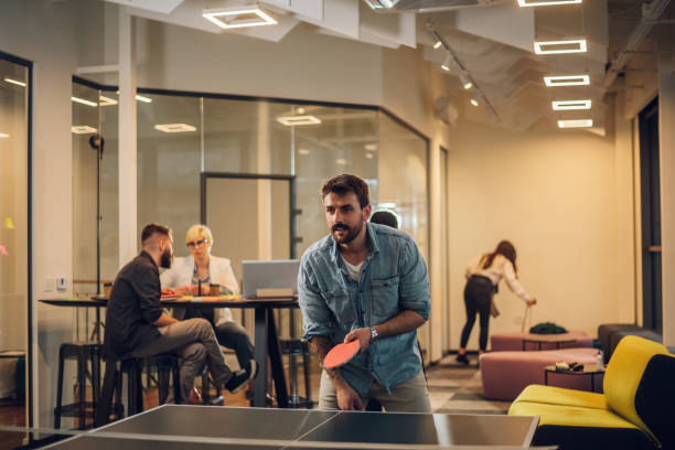 istock Young people playing table tennis in the office at work 1402083459
