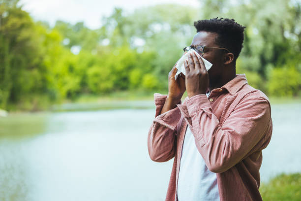 istock Allergic black man blowing on wipe in a park on spring season 1402085825