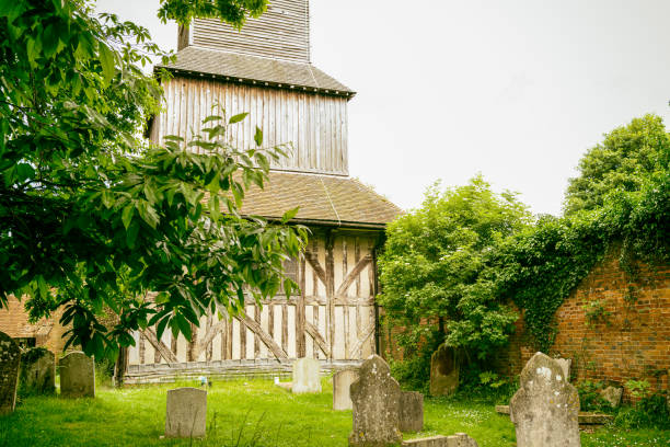 Aged look to a rare wooden bell tower seen in a rural church and cemetery. The find timber work can be seen as well as the wooden bell tower itself. blackmore vale stock pictures, royalty-free photos & images