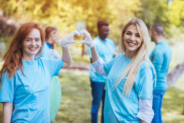 A group of volunteers are cleaning and collecting plastic outside in a public park.