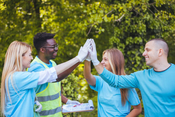 istock Multi-ethnic group of people, environmental volunteers, giving group high five after successful cleaning nature from garbage 1402086952