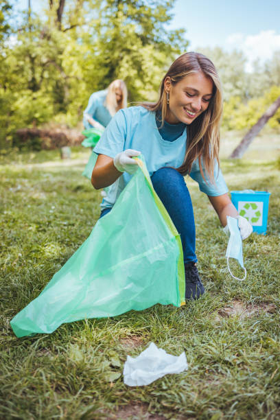 spontaneous photo of a cute young adult blondie, cleaning up the park - sustainable resources environment education cleaning imagens e fotografias de stock