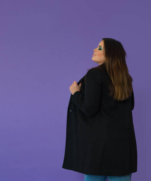 istock back view of and elegant makeuped lady holding a black coat while smiling with her head raised 1402088665