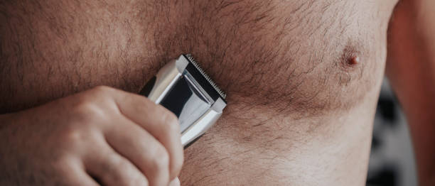 istock trims his chest with an electric trimmer, banner 1402090332