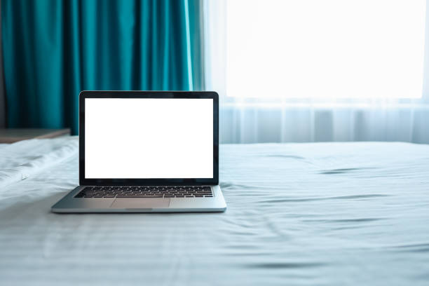 istock Mock up Blank screen laptop on the bed for advertising and text. 1402092679