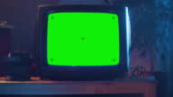 istock Close Up Footage of a Dated TV Set with Green Screen Mock Up Chroma Key Template Display. Nostalgic Retro Nineties Technology Concept. 1402092855