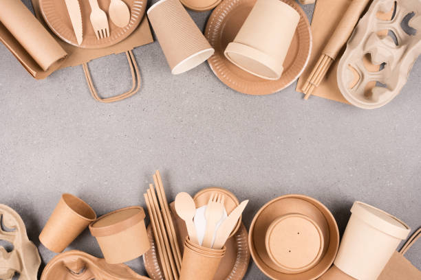 istock Frame made with eco paper tableware and utensils - paper cups, containers and wooden bamboo cutlery over gray concrete background with copy space. Sustainable food packaging concept 1402096169