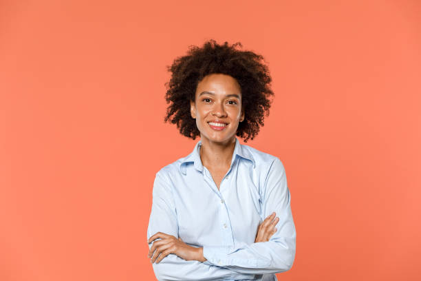 retrato de uma linda mulher afro-americana com cabelo encaracolado na casa dos 30 anos posando de camisa azul sem maquiagem foto - human joint flash - fotografias e filmes do acervo