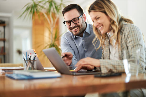istock Happy business couple working on a computer at home office. 1402096741