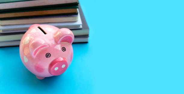 istock Pink piggy bank with books 1402097245