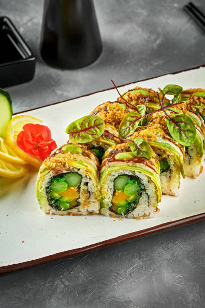 istock Vegetarian sushi rolls with avocado, mango and sauces isolated on a white plate. Close-up 1402097699