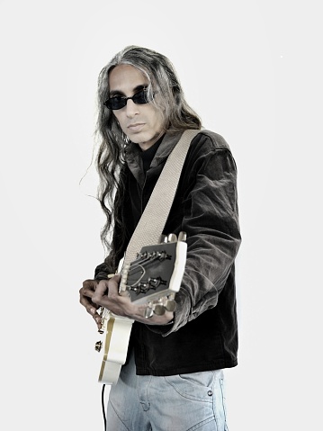 Long haired man with dark shades playing electric guitar
