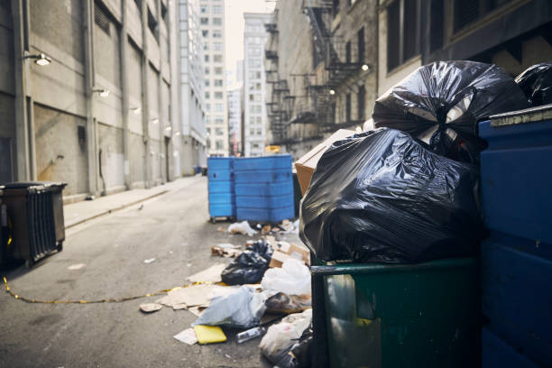 Mess and full garbage cans in narrow alley Mess and full garbage cans in narrow alley amidst buildings in city."n overflowing trash dumpster stock pictures, royalty-free photos & images