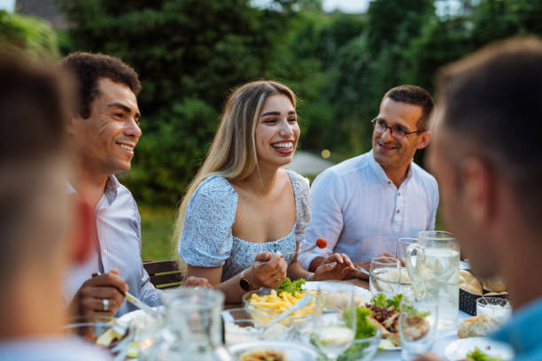 istock Multi-ethnic group of people eating in the backyard in summer evening and having fun 1402104423
