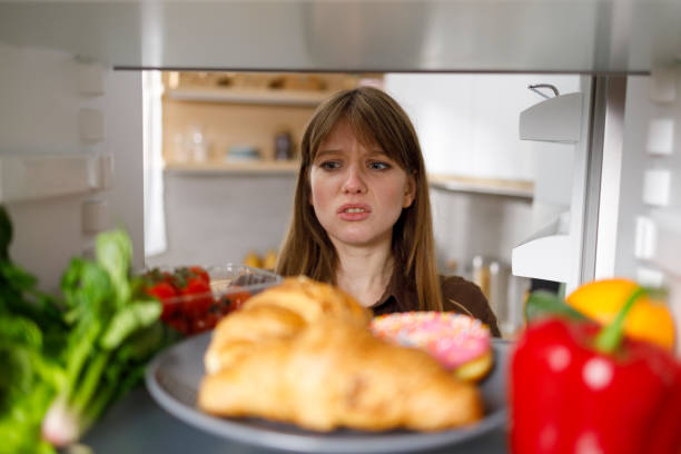 istock Sad girl looks into the fridge 1402104503