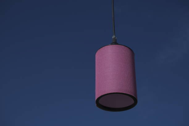 Violet color lamp hanged front of the blue sky