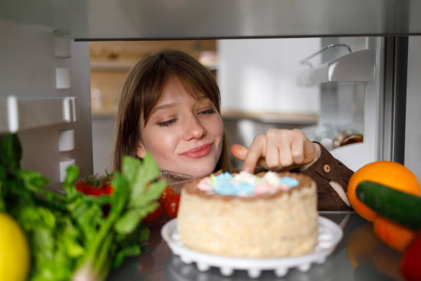 istock Girl tasting cake with finger in fridge 1402104841