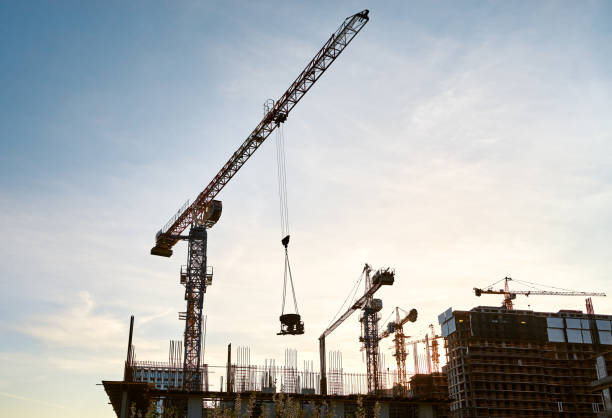 istock Silhouette of tower cranes and high-rise buildings under construction at a construction site at sunset 1402107157