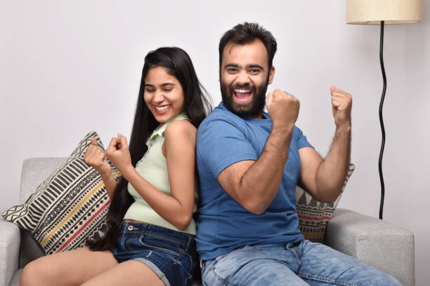 istock Young happy couple sitting on sofa 1402110241