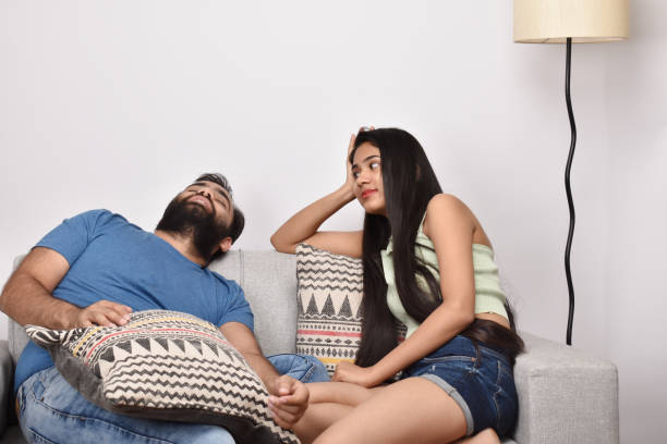 istock Young happy couple sitting on sofa 1402110891