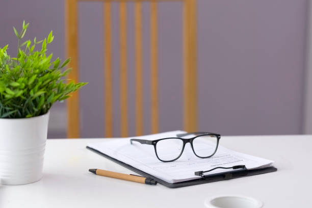 istock Empty doctor's office, work desk with a tablet for papers, glasses and a pen for notes. 1402114077