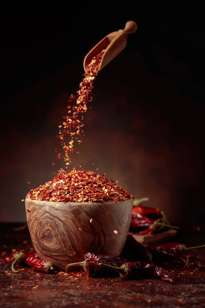istock Chilli flakes are poured into a wooden dish. 1402114730