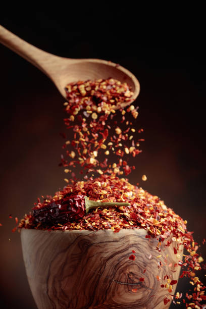 istock Chilli flakes are poured into a wooden dish. 1402114742