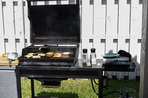 Barbecue full of hamburguer and cheesebuguers grilling