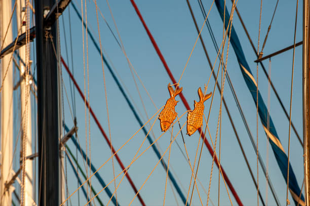 Two fish ornament stretching sailboat rope - horizontal shot