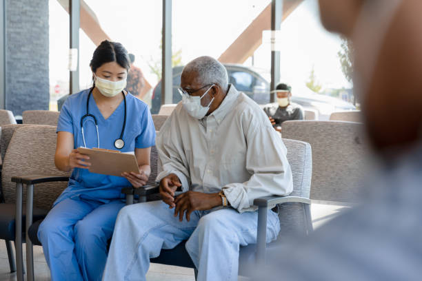 Nurse helps elderly patient The nurse helps the senior adult patient to fill out his paperwork to see the doctor. triage stock pictures, royalty-free photos & images