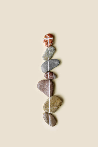 istock Aesthetic minimal flat lay sea pebble stones with white line, beige background. Composition from natural colored stone on the same level. Balance or harmony concept, vertical row rocks. 1402122932