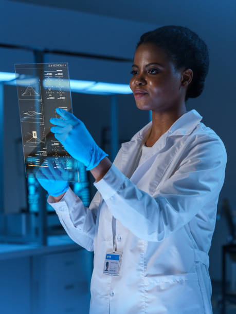istock A young smiling female scientist in a lab coat works with a small HUD screen in a modern laboratory, we see her half turned from the waist up 1402122973