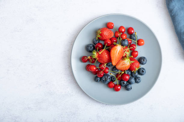 istock Strawberries, cherries and blueberries on a dark plate, top view 1402123692