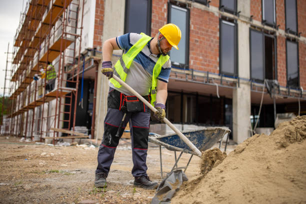 At the construction site, Caucasian male construction worker, fill the cart with sand