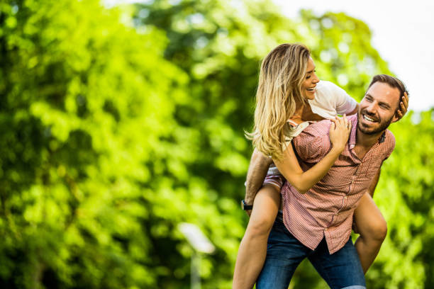 istock Happy couple having fun while piggybacking in the park on spring day. 1402125386