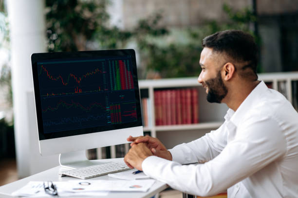 istock Smart Indian male crypto trader, investor, looking at computer screen, analyze trading charts in the stock market of a digital cryptocurrency exchange, buys and sells cryptocurrency, analysis dynamics 1402125931
