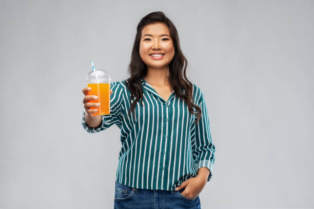 istock asian woman with juice in plastic cup with straw 1402127207