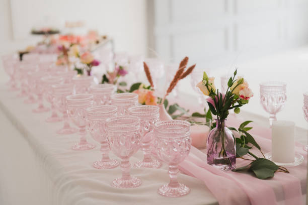 istock Table setting at the wedding reception. Floral compositions with beautiful flowers and greenery, candles, laying and plates on a decorated table. 1402127331