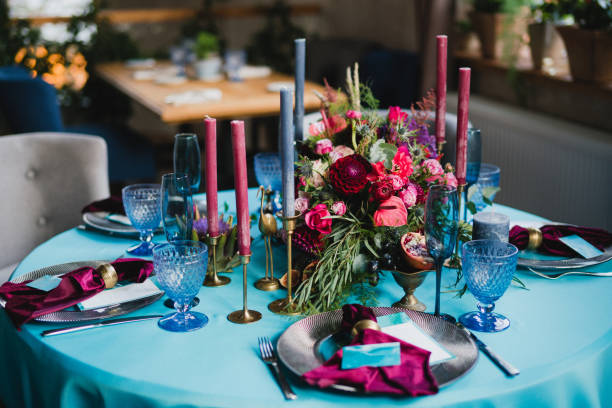 istock Table setting at the wedding reception. Floral compositions with beautiful flowers and greenery, candles, laying and plates on a decorated table. 1402127668