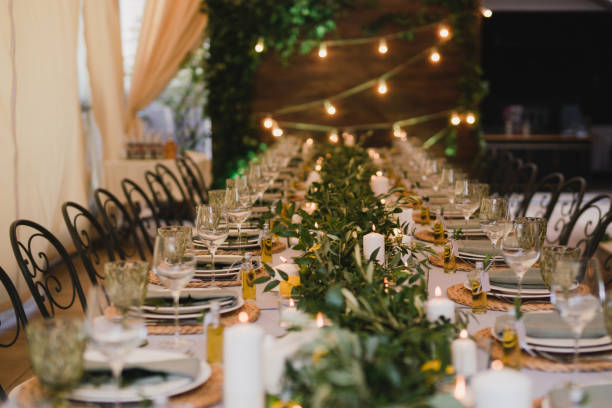 istock Table setting at the wedding reception. Floral compositions with beautiful flowers and greenery, candles, laying and plates on a decorated table. 1402127765