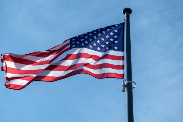 istock American flag waving in the wind against blue sky. 1402129136