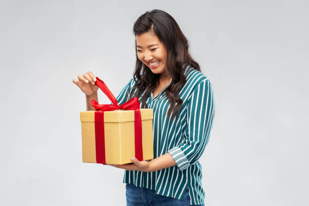 istock happy asian woman opening gift box 1402129265